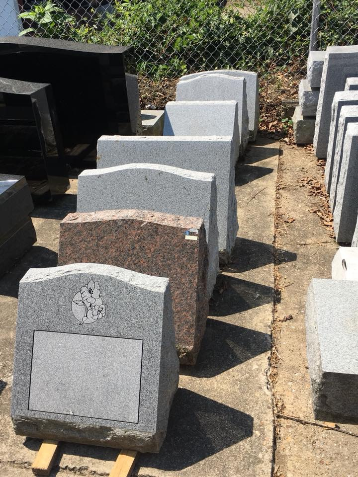 A row of gravestones are lined up on a sidewalk.