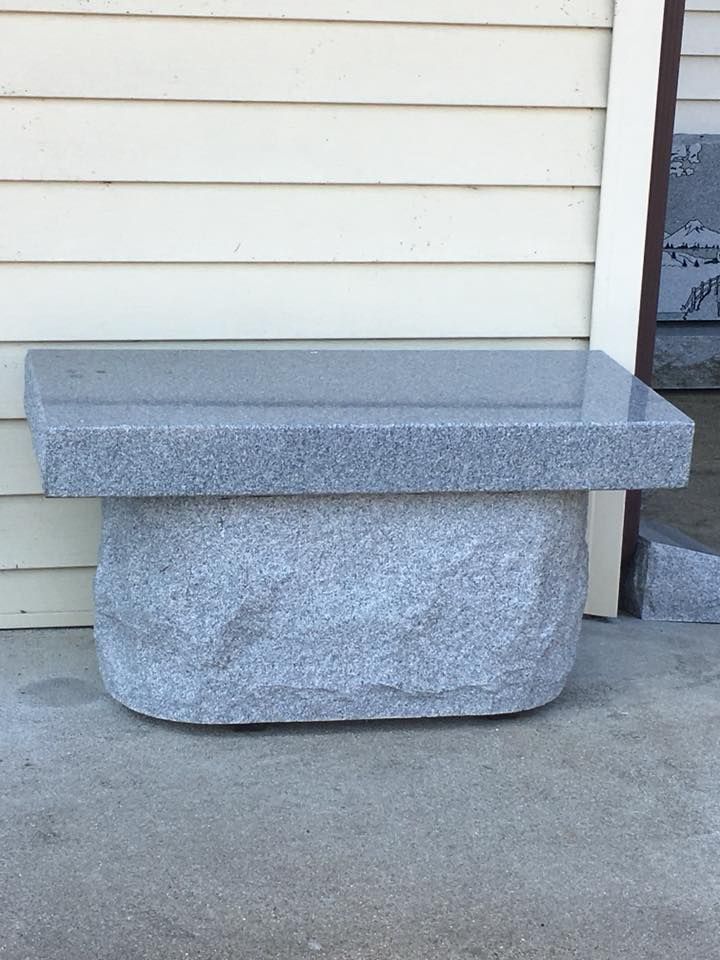 A stone bench is sitting in front of a house