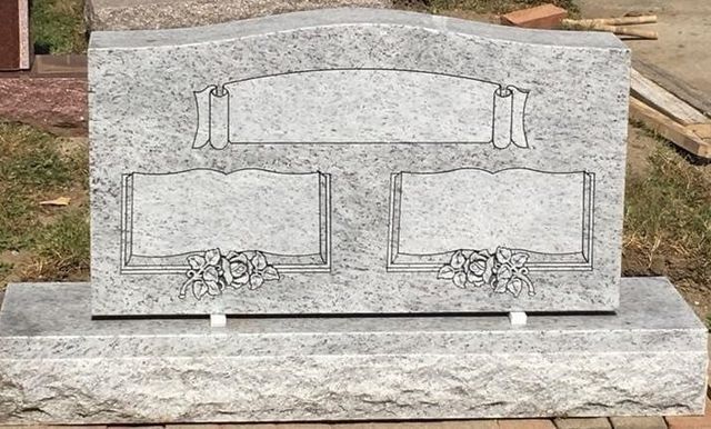 A gravestone is sitting on top of a grave in a cemetery.