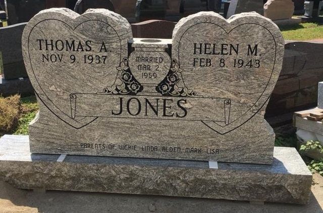A gravestone for thomas and helen jones in a cemetery.