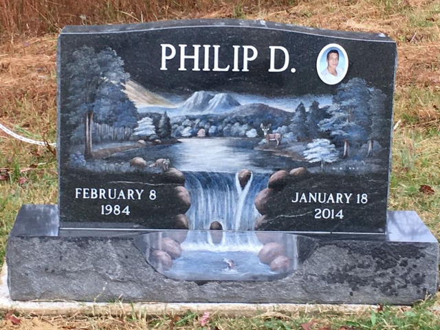 A gravestone for philip d. with a waterfall on it