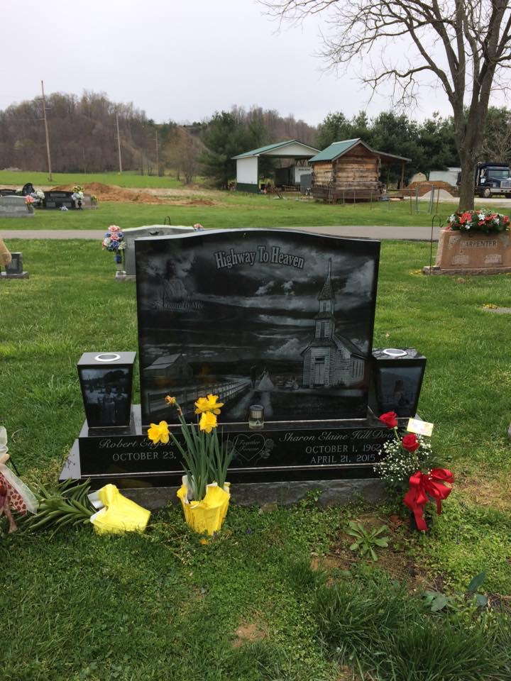 A grave with flowers and candles in a cemetery.