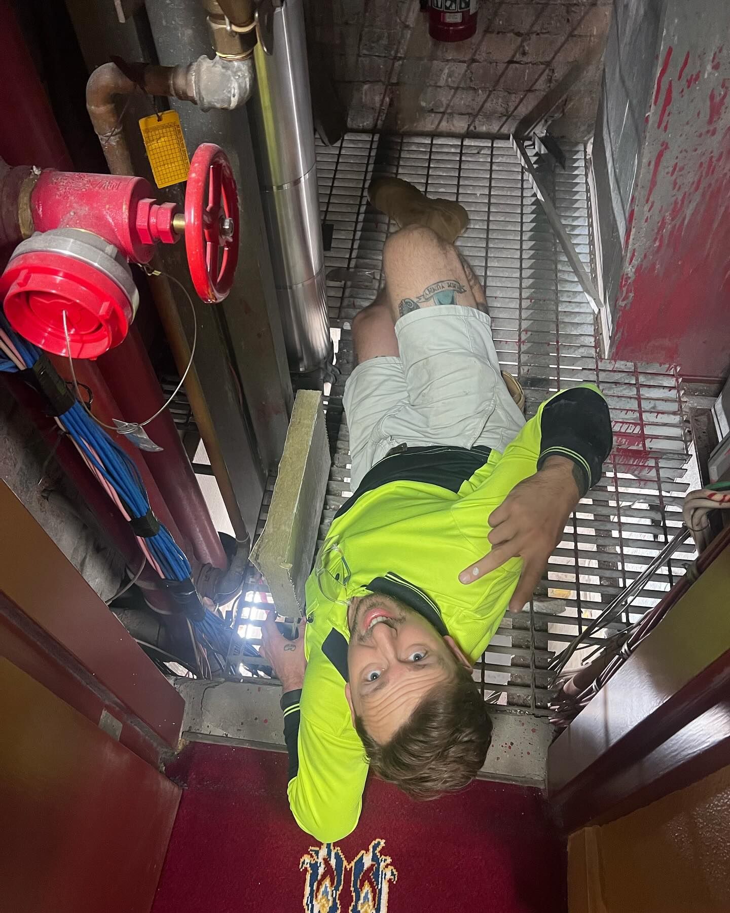 Man Working in a Confined Space With Pipes and a Red Fire Hydrant — Hunter Fire & Safety in Edgeworth, NSW