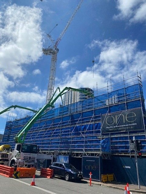 Construction Site With Crane, Blue Scaffolding, Concrete Pump Truck — Hunter Fire & Safety in Edgeworth, NSW
