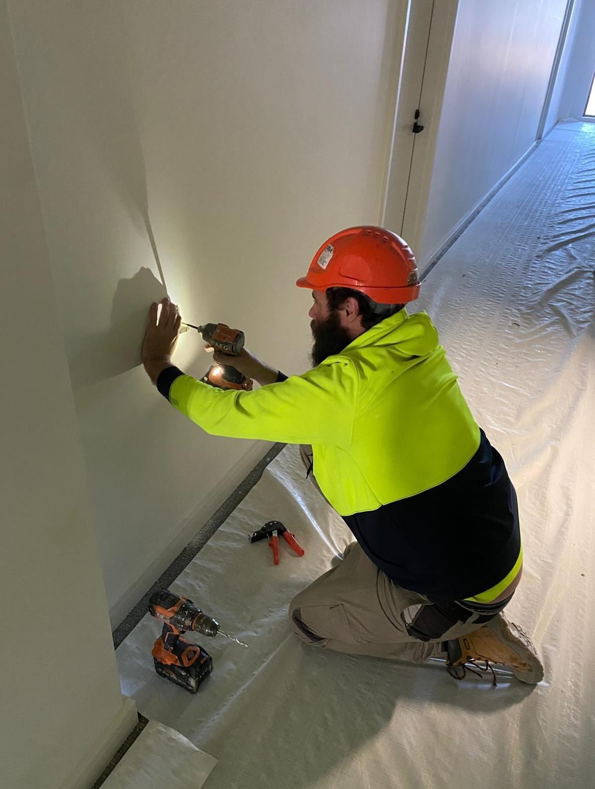 Construction Worker in Hard Hat Drills Into a Wall — Hunter Fire & Safety in Central Coast, NSW