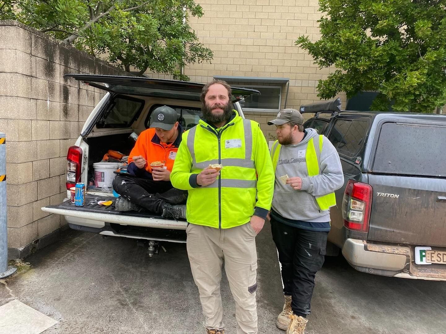 Three Construction Workers Taking a Break Near Their Trucks — Hunter Fire & Safety in Central Coast, NSW