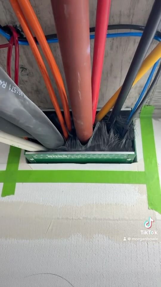 Cables of Various Colors Emerge From a Rectangular Opening in a Concrete Wall — Hunter Fire & Safety in Edgeworth, NSW