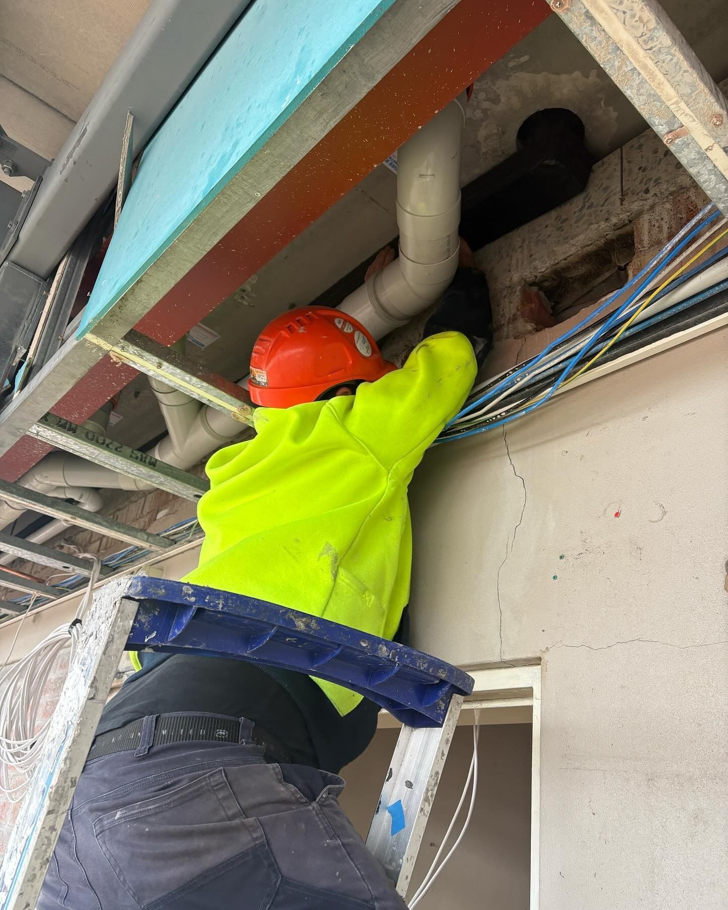 Construction Worker in Safety Gear on Ladder — Hunter Fire & Safety in Central Coast, NSW