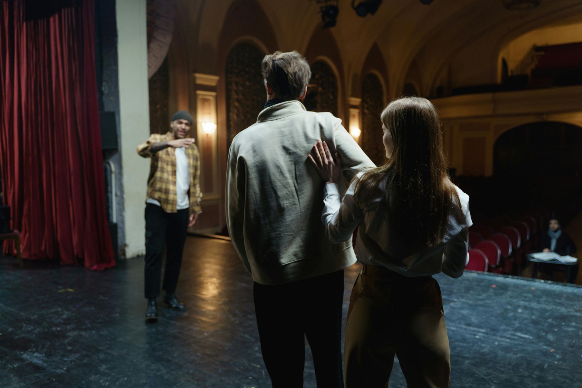A man and a woman are standing on a stage in a theater.