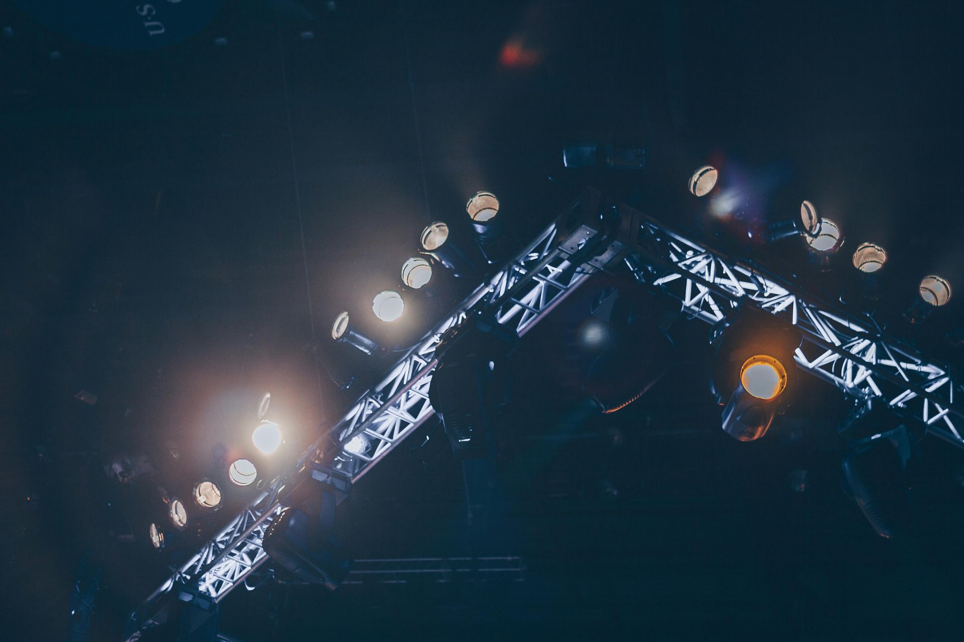 A bunch of lights are shining on a stage at night.