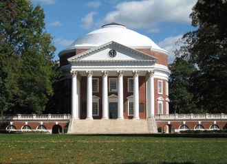 Rotunda building, University of Virginia, white columns, red brick, dome, green lawn, trees.