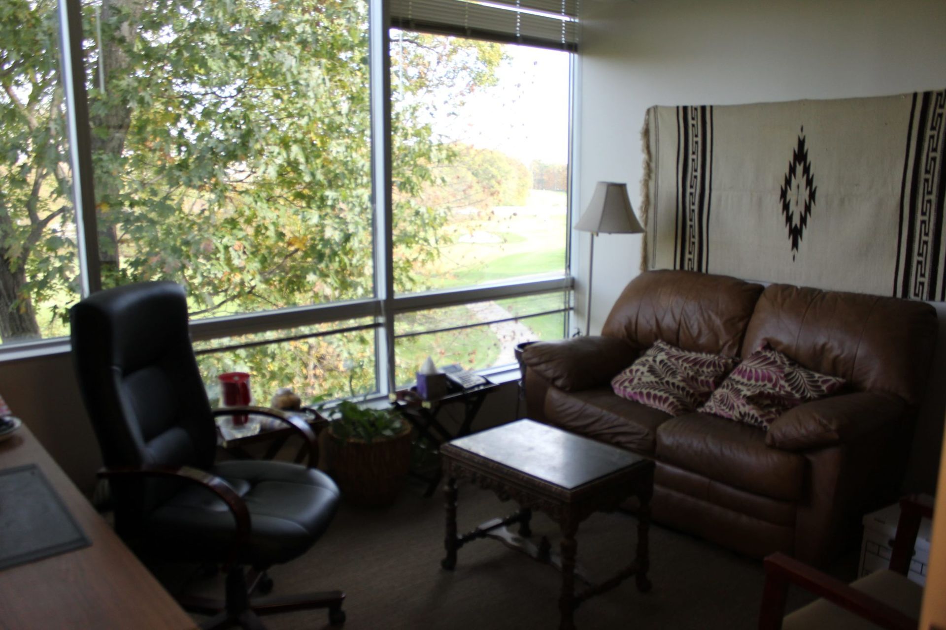 A living room with a brown couch and a black chair