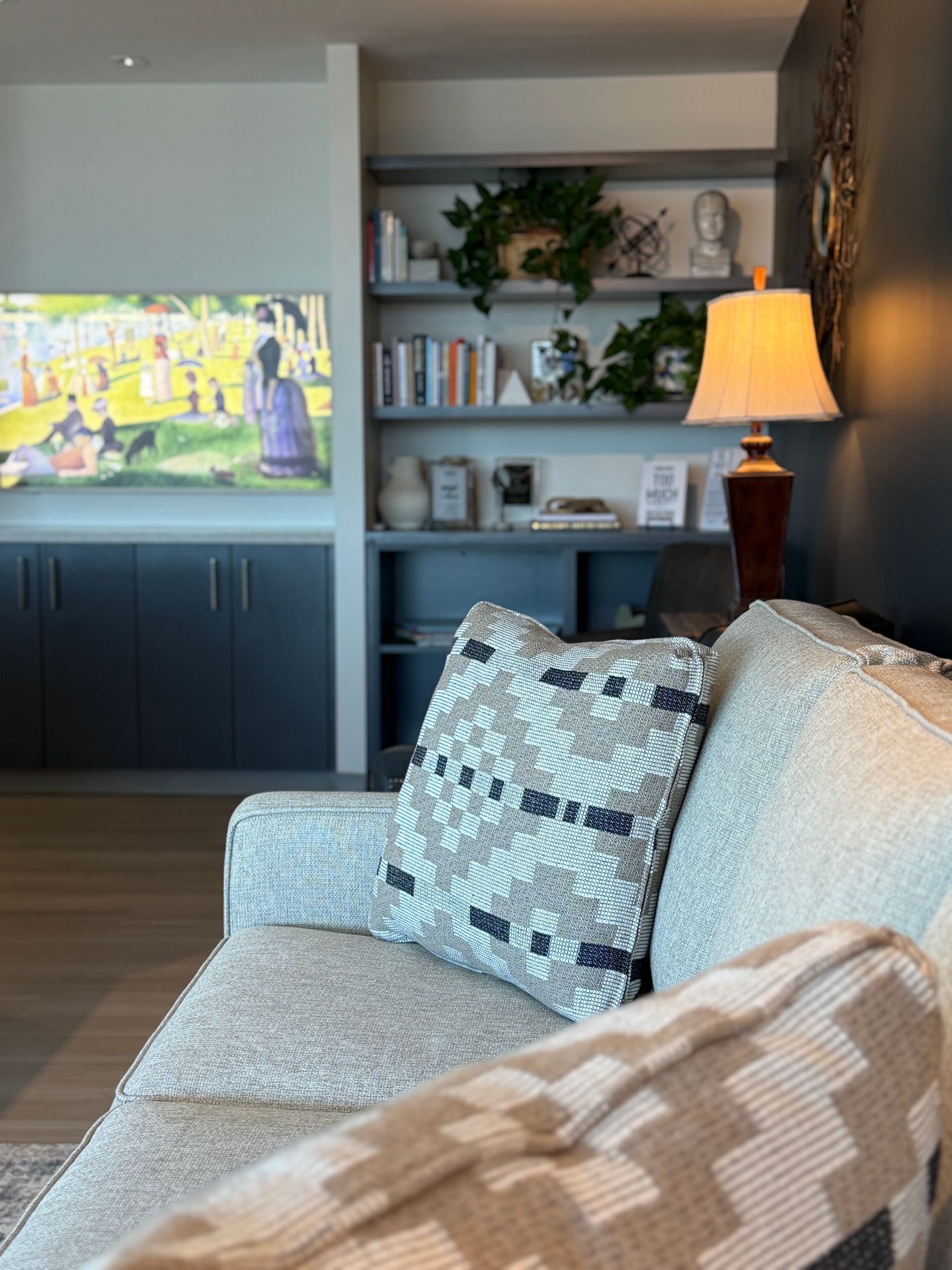 A living room with a couch , chair , lamp and television.