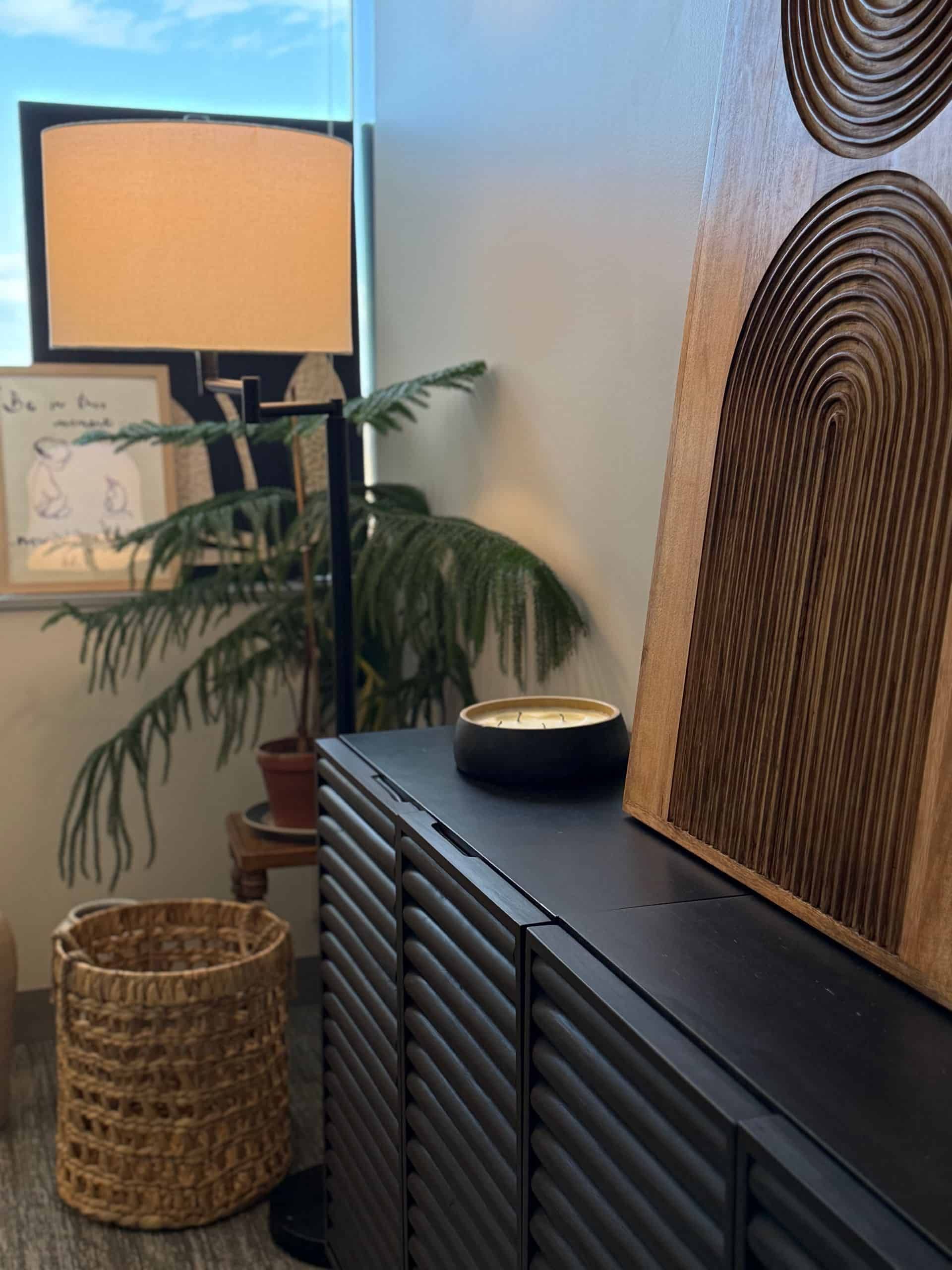 A wicker basket sits next to a lamp in a room