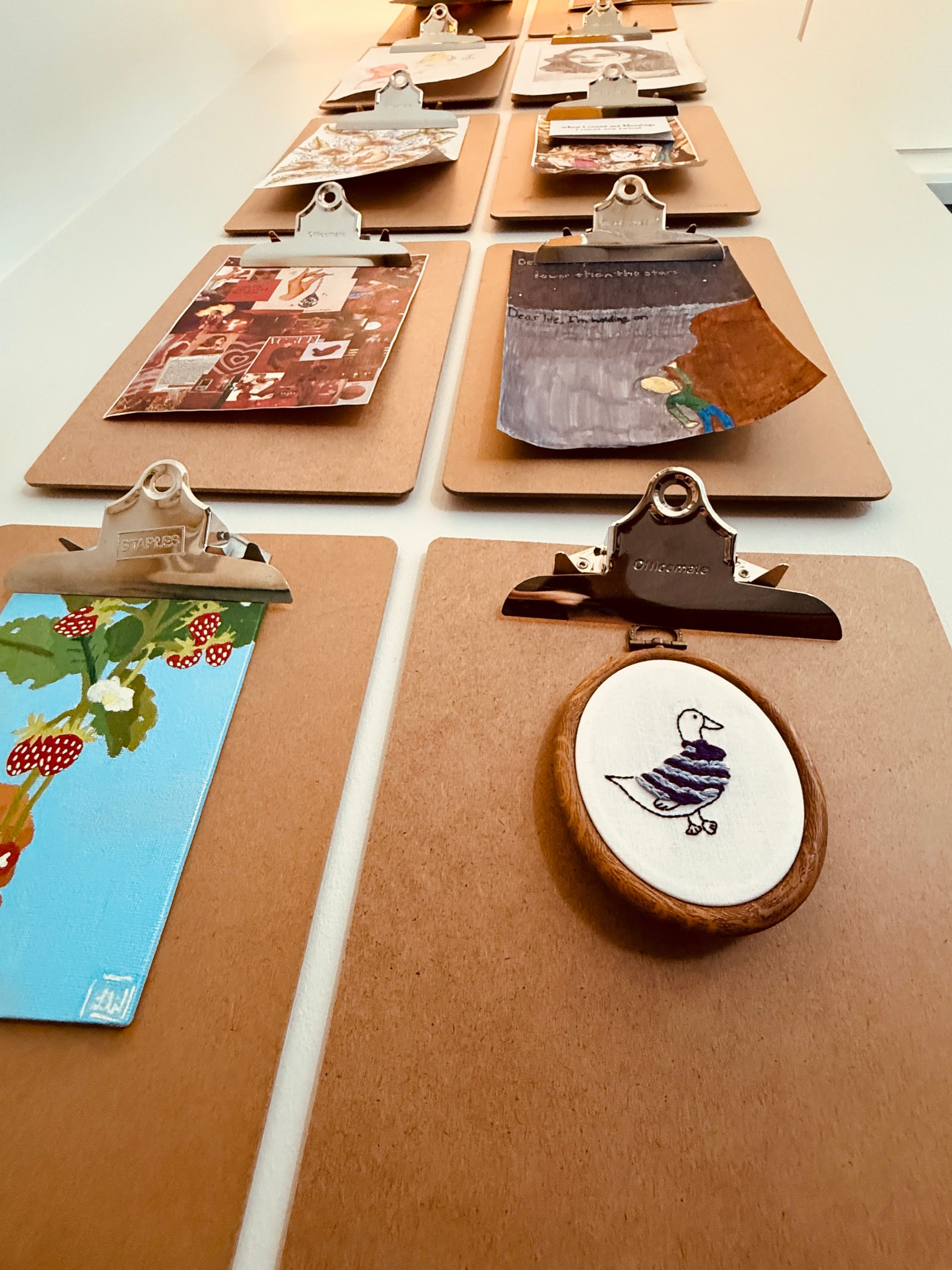 A row of clipboards with a picture of a bird i Angela Brown's office