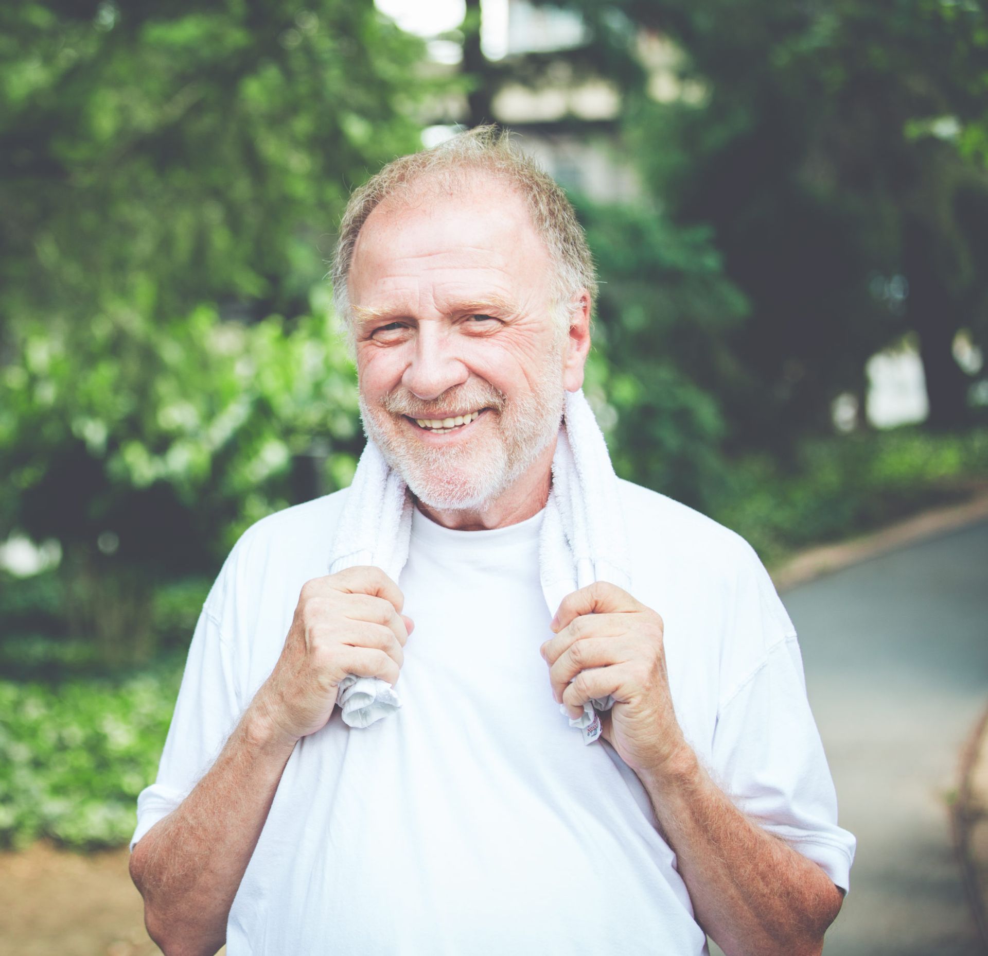 A man with a towel around his neck is smiling for the camera.