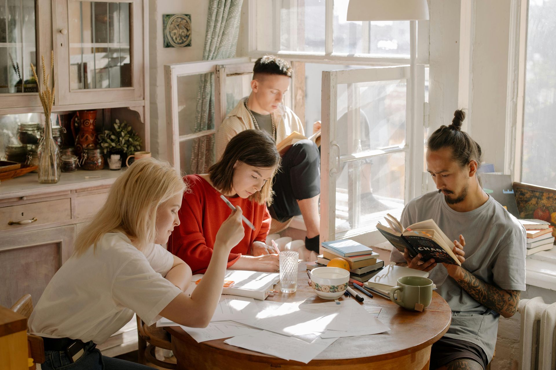 A group of people are sitting around a table reading books about mental health