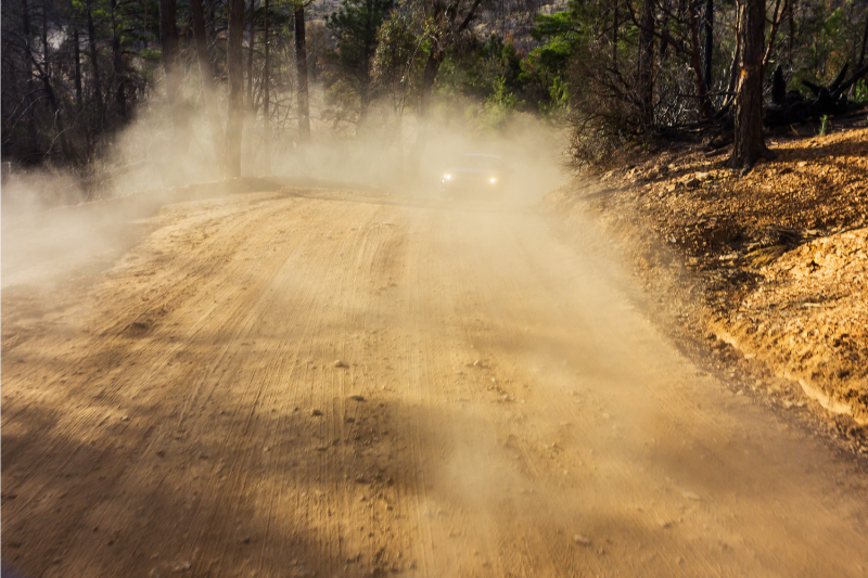 A car driving on a dusty road