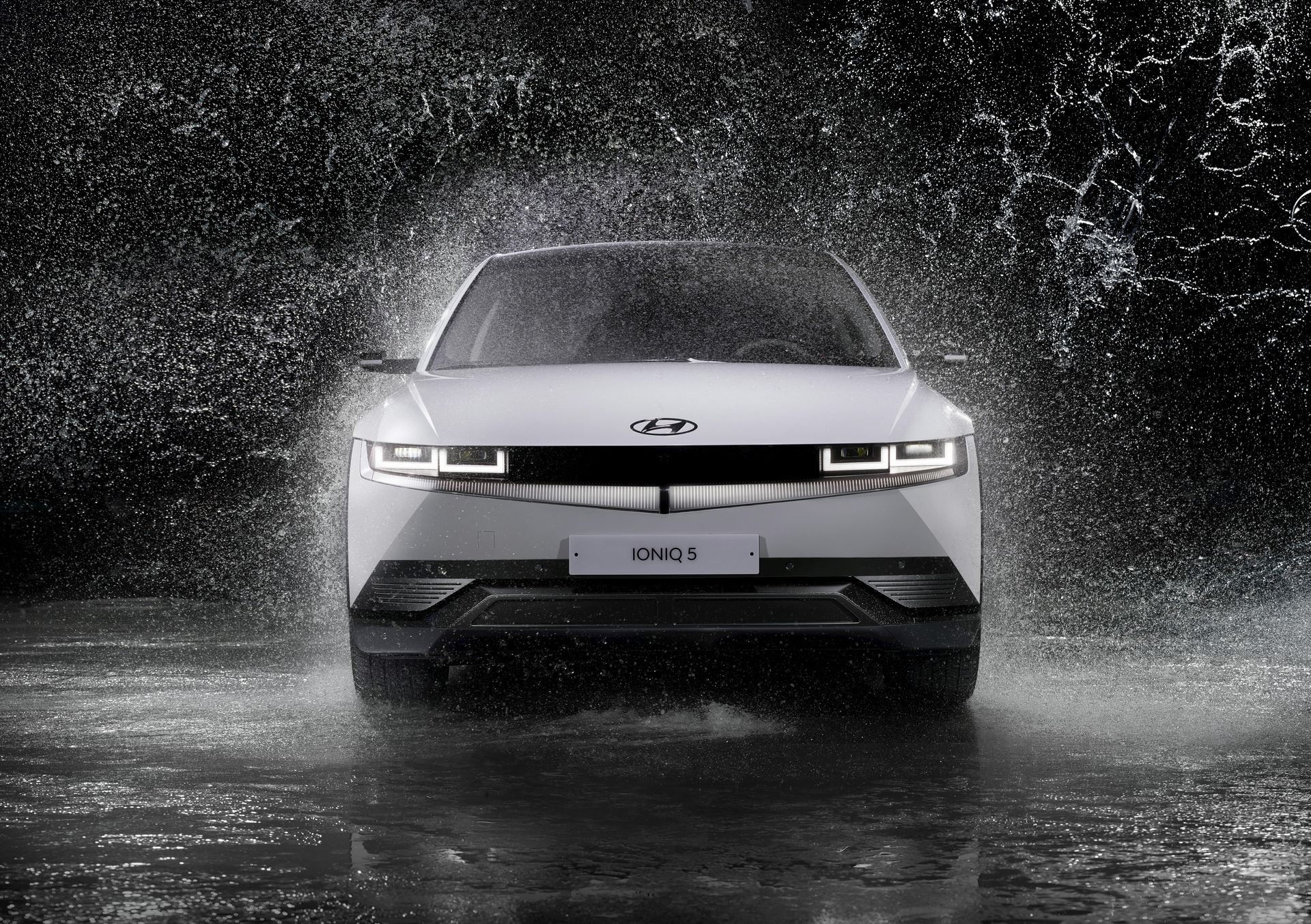 White Hyundai IONIQ 5 electric car driving through water.