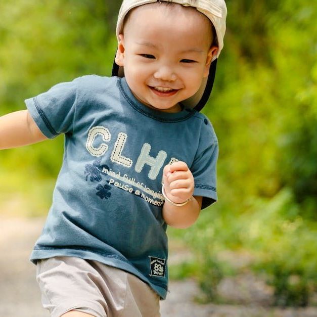 A little boy wearing a blue shirt that says clh on it