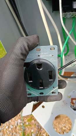 A person is holding a electrical outlet in their hand.