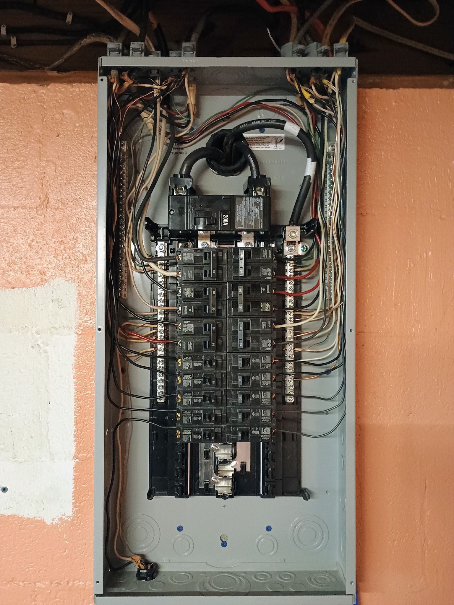 A large electrical box is hanging on a wall.