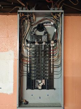 A large electrical box is hanging on a wall.
