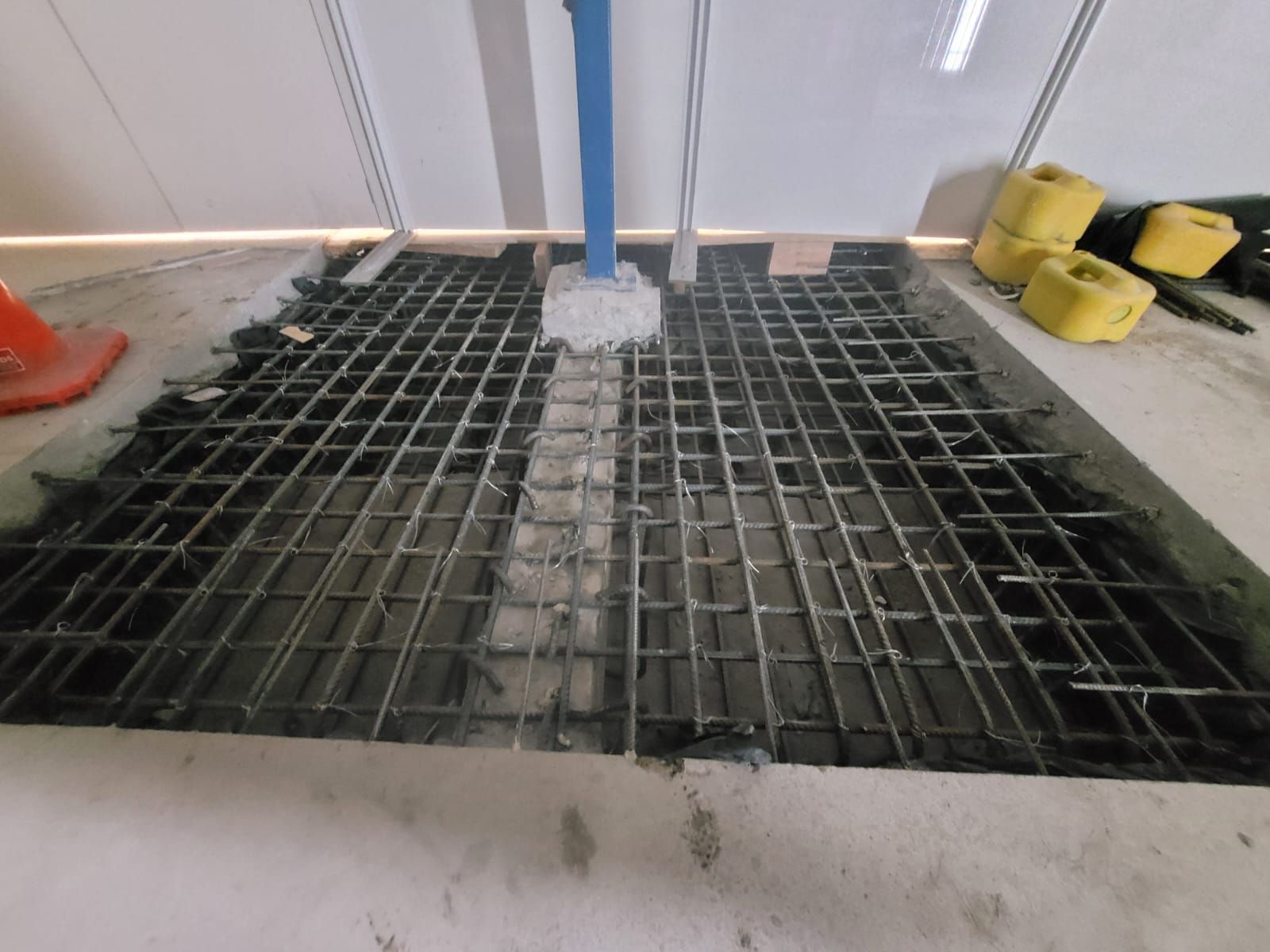 A metal grate is sitting on a concrete floor.