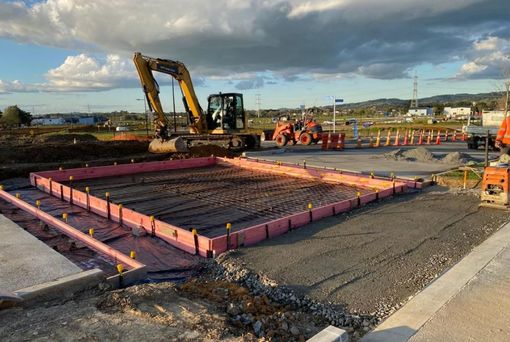 A construction site with a large excavator in the background.