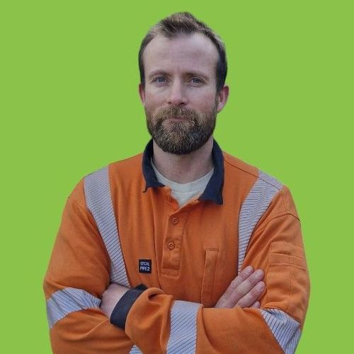 A man with a beard wearing an orange safety shirt