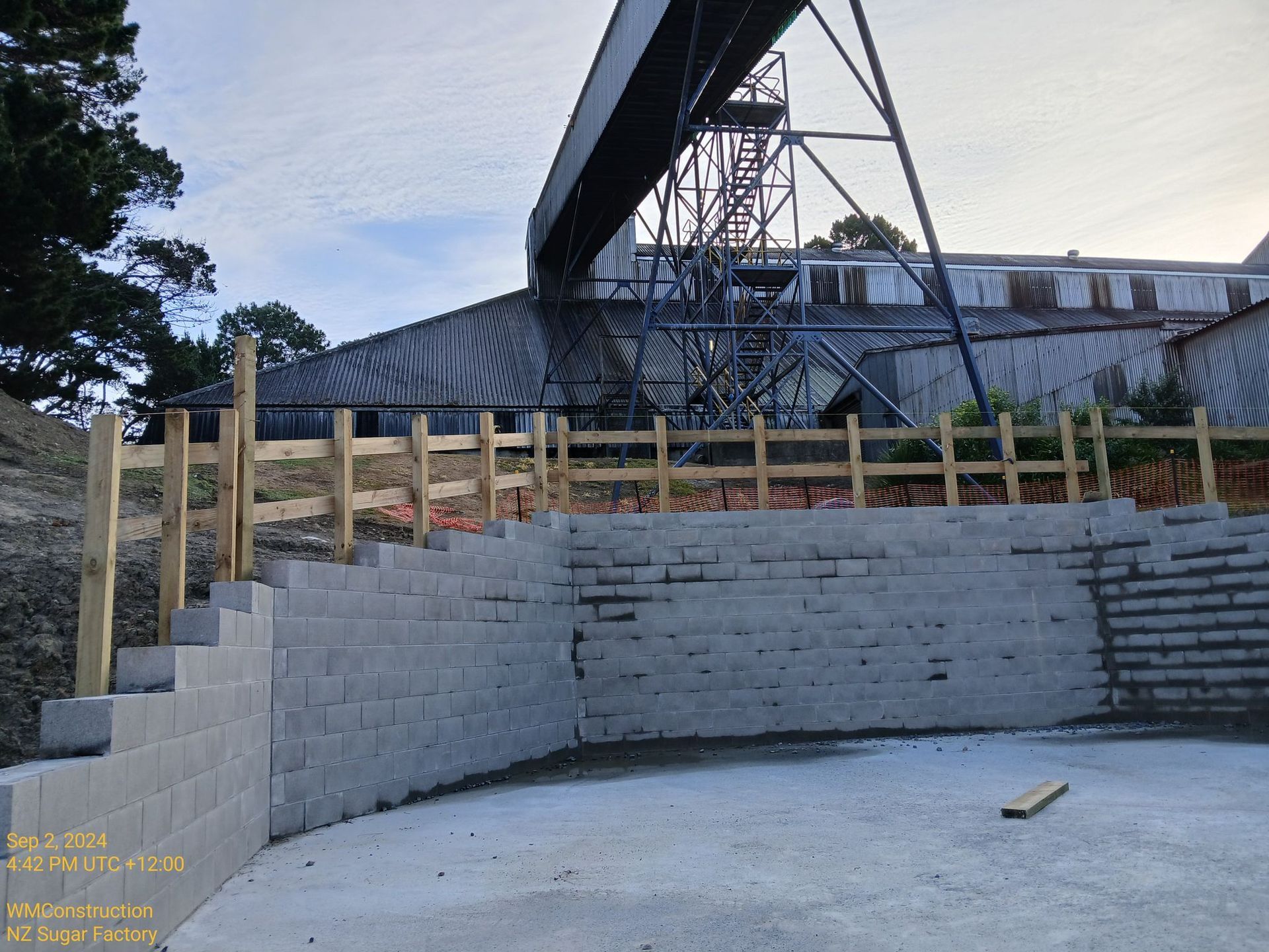 A construction site with a brick wall and a wooden fence