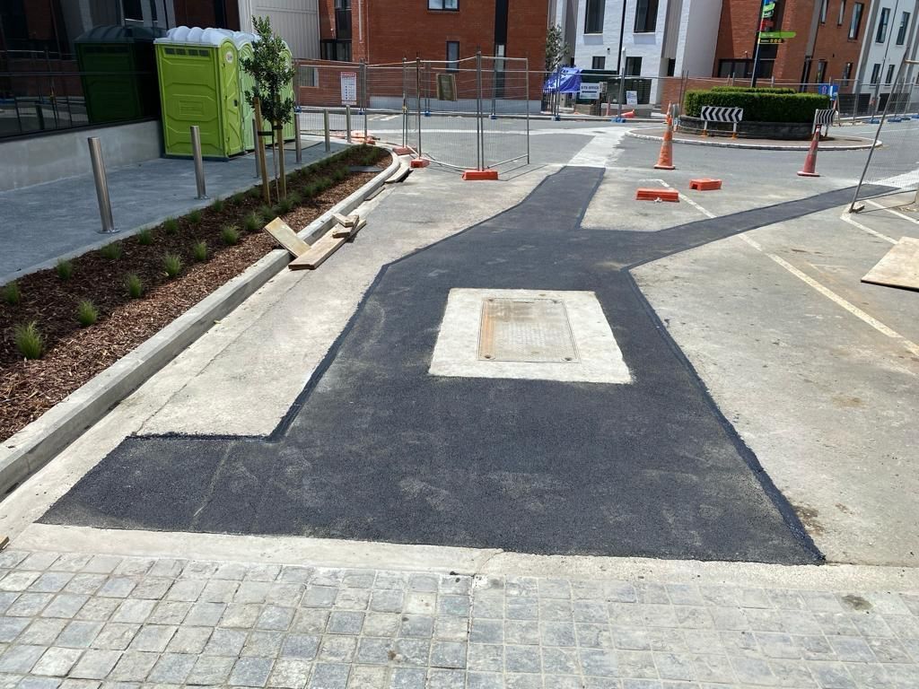 A black asphalt road with a white square in the middle