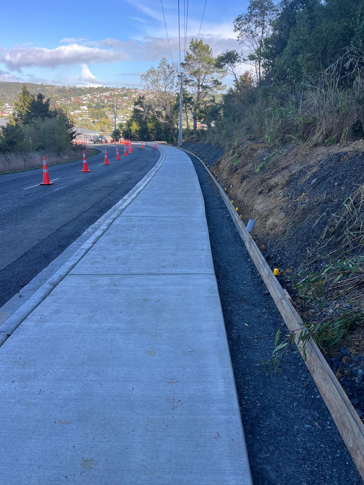 A concrete walkway along the side of a road.