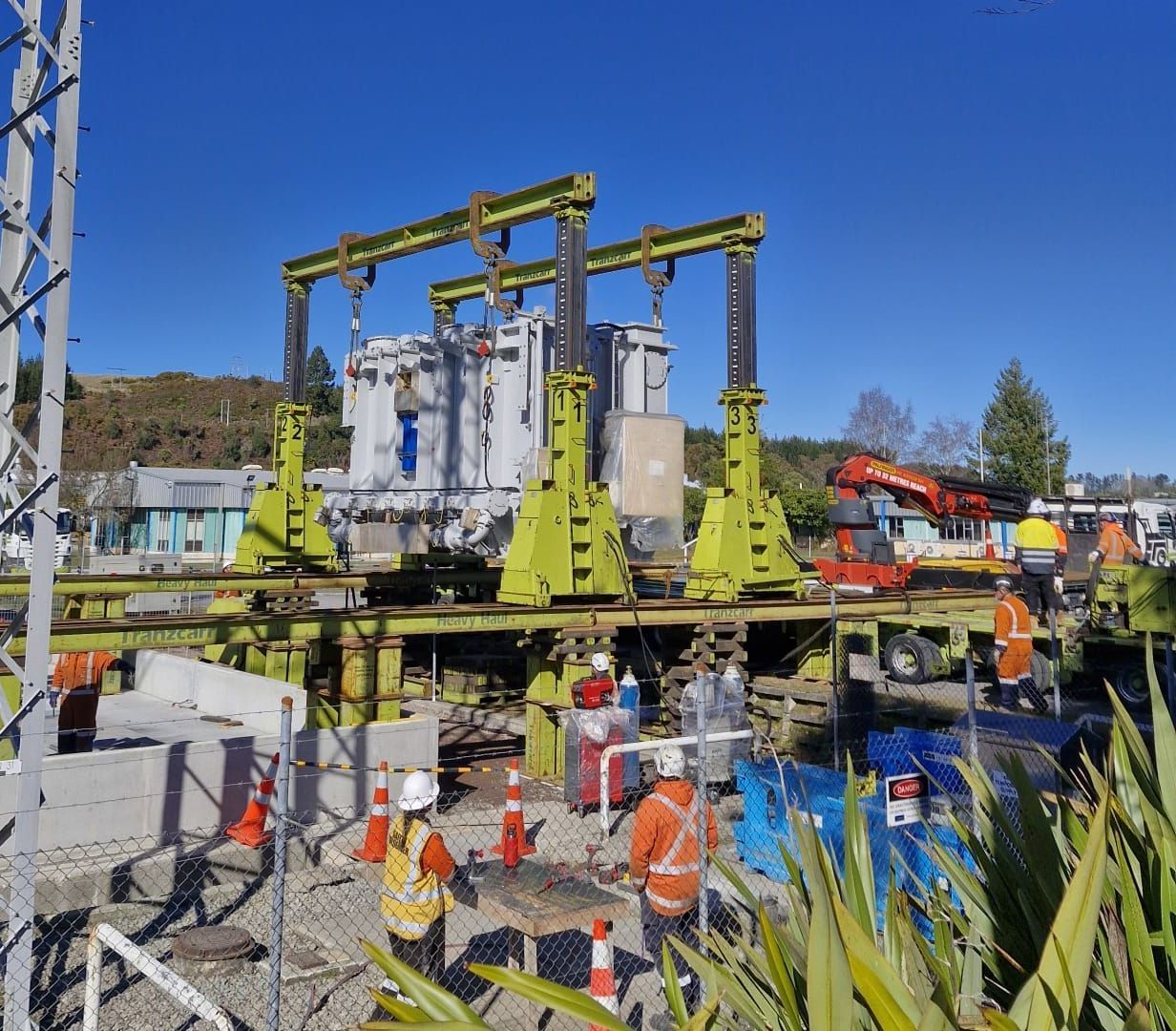 A group of construction workers are working on a large transformer