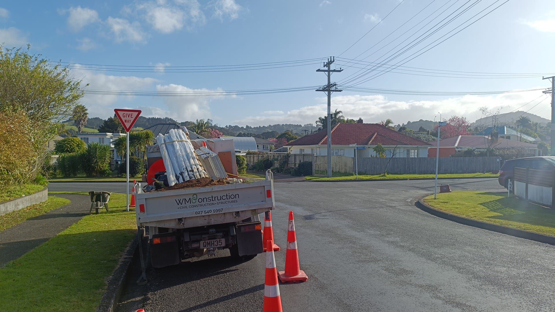 A dump truck is parked on the side of the road next to a stop sign