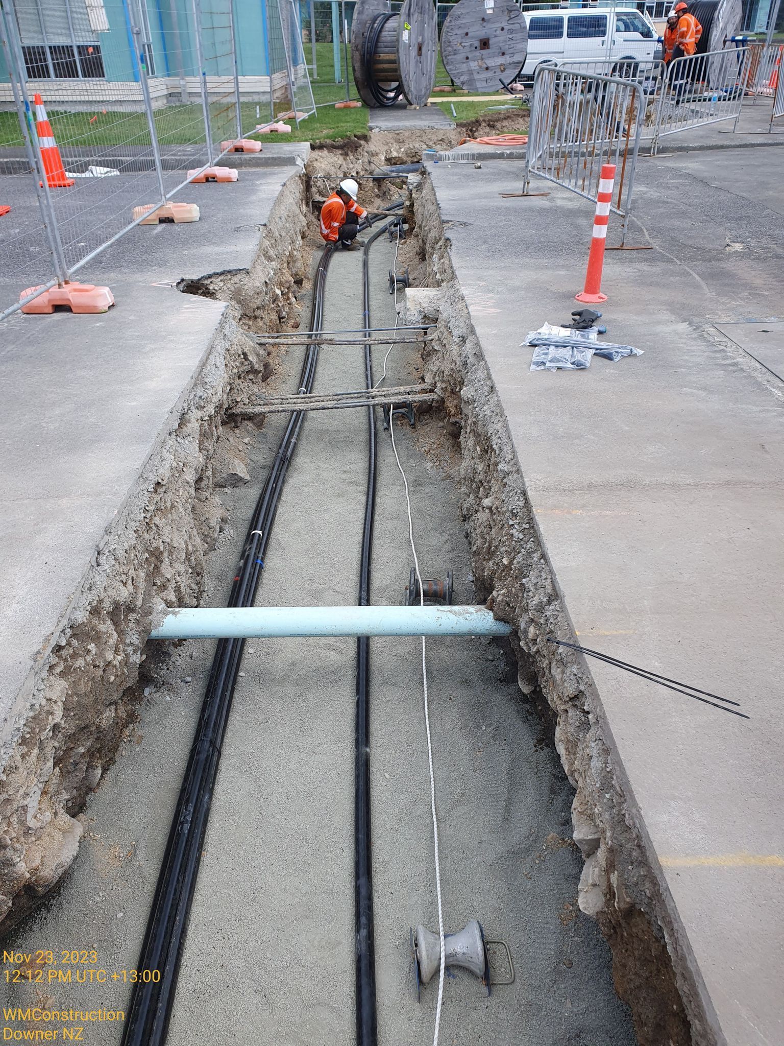 A man is working on a pipe in a trench.