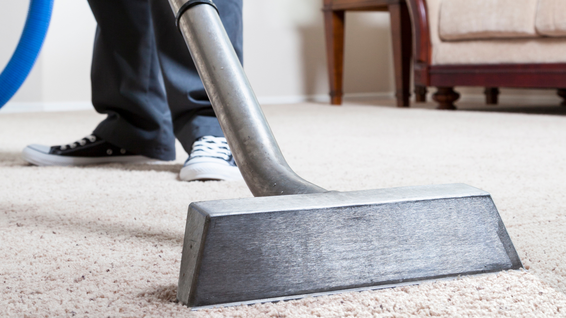 Professional carpet cleaners using hot water extraction on beige carpet flooring