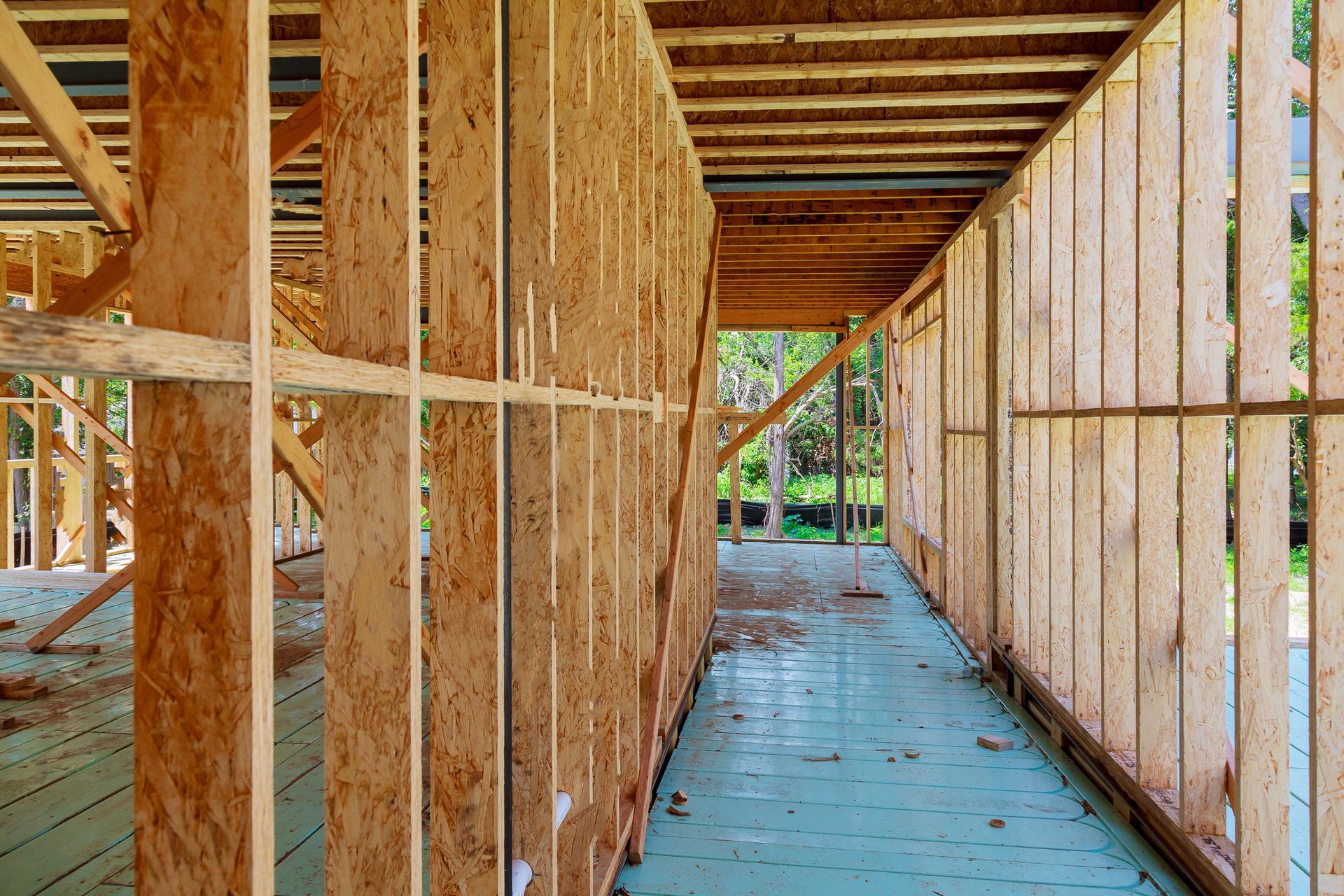 A hallway in a house under construction with wooden beams.