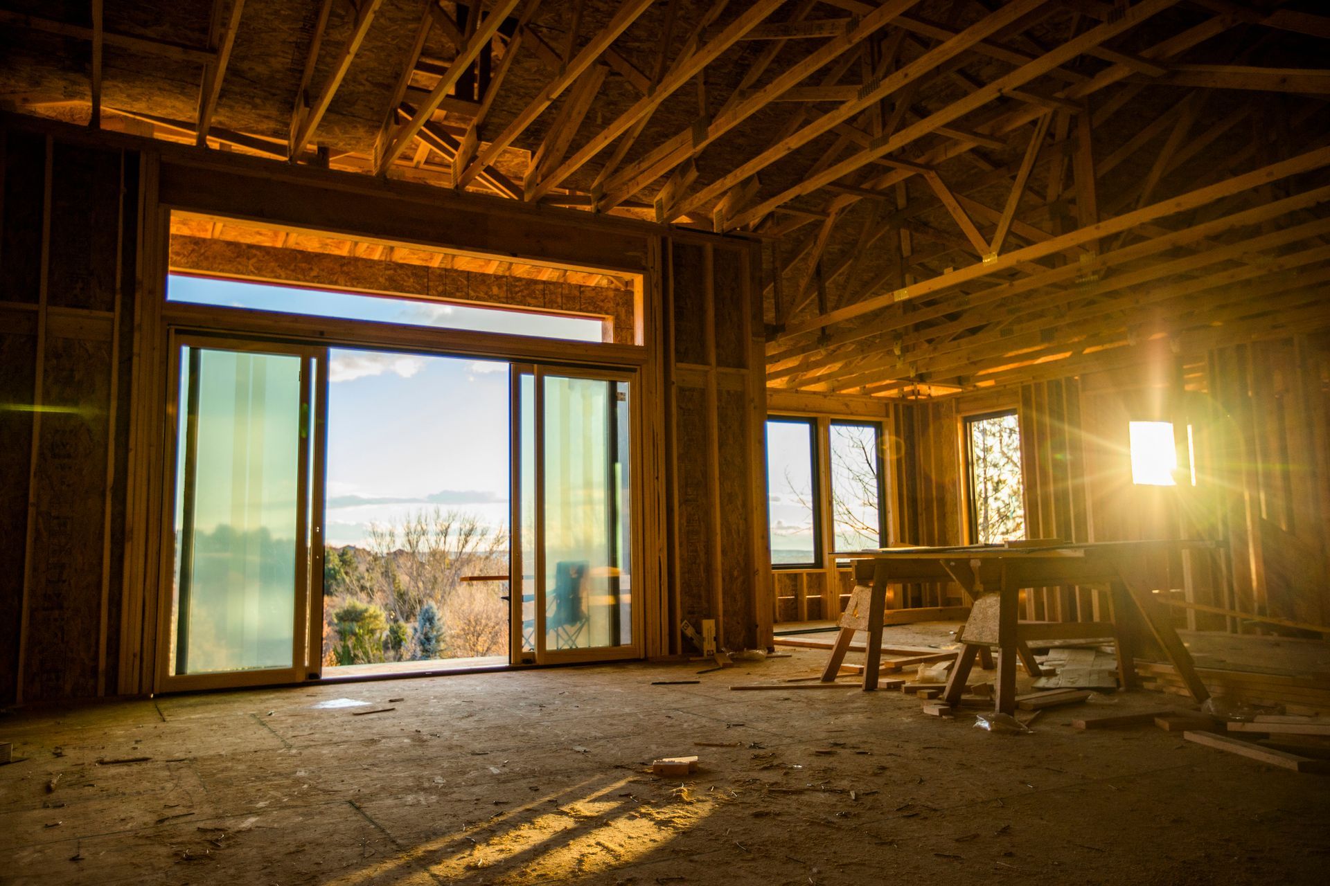 The sun is shining through the windows of a house under construction.