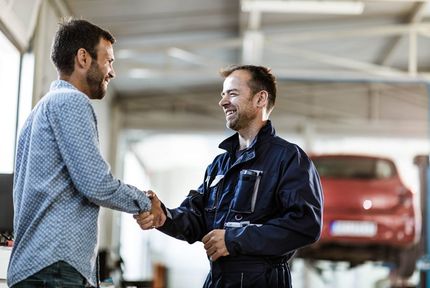 happy customer shaking hands with mechanic