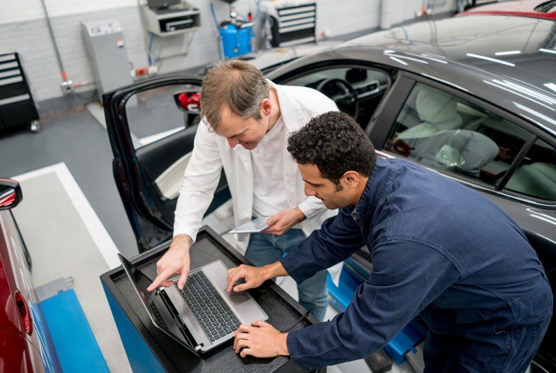 mechanic and customer looking at car diagnostics