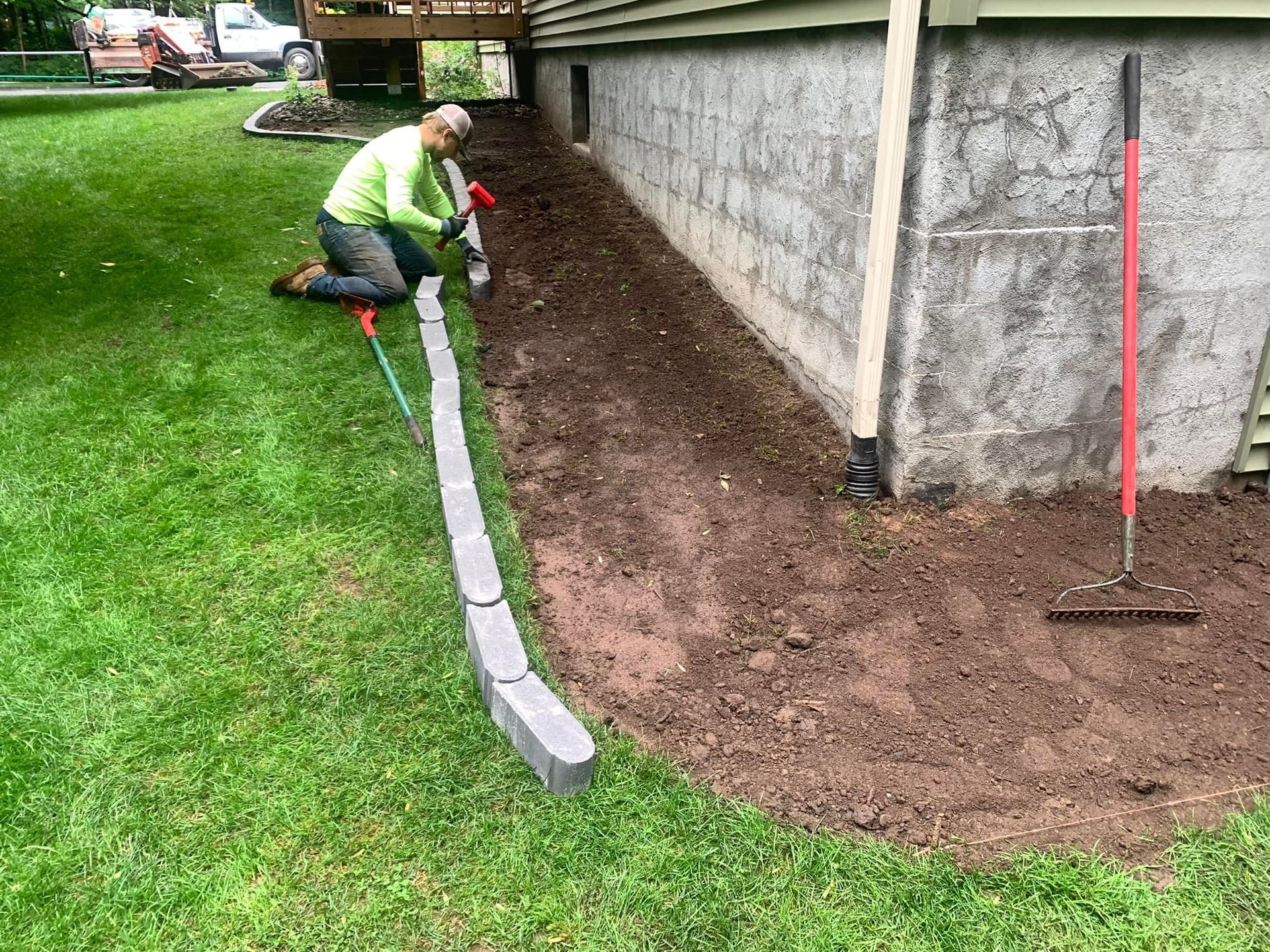 A man is kneeling down in front of a house.