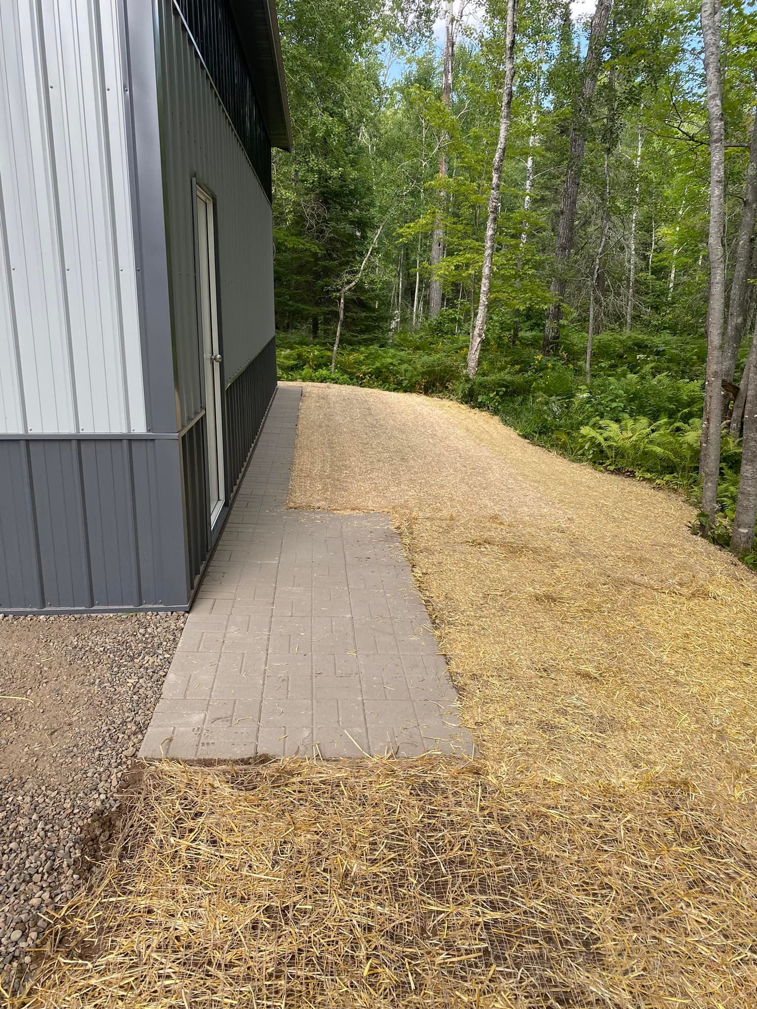 There is a walkway leading to a building in the woods.