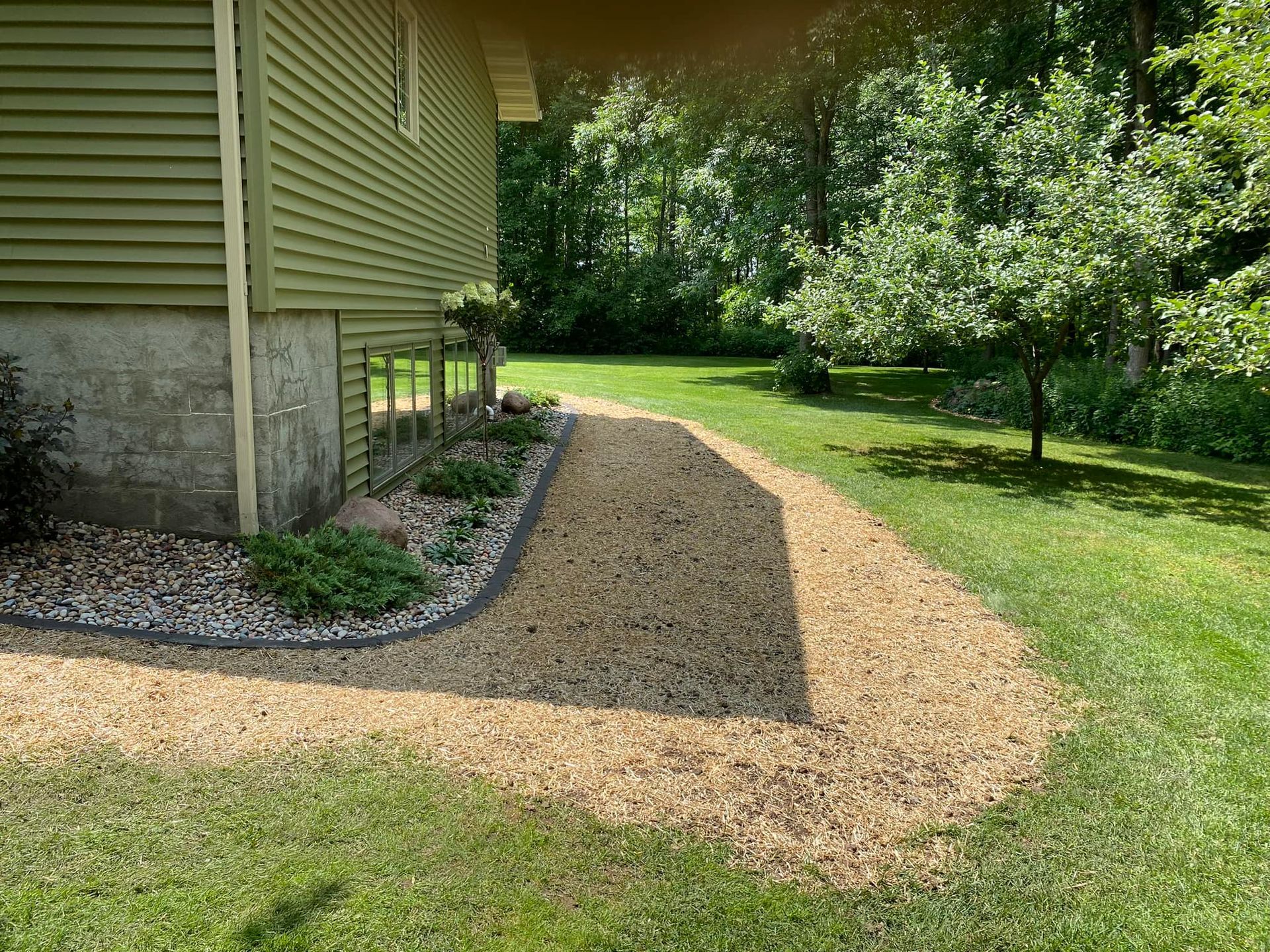There is a gravel path leading to the side of the house.