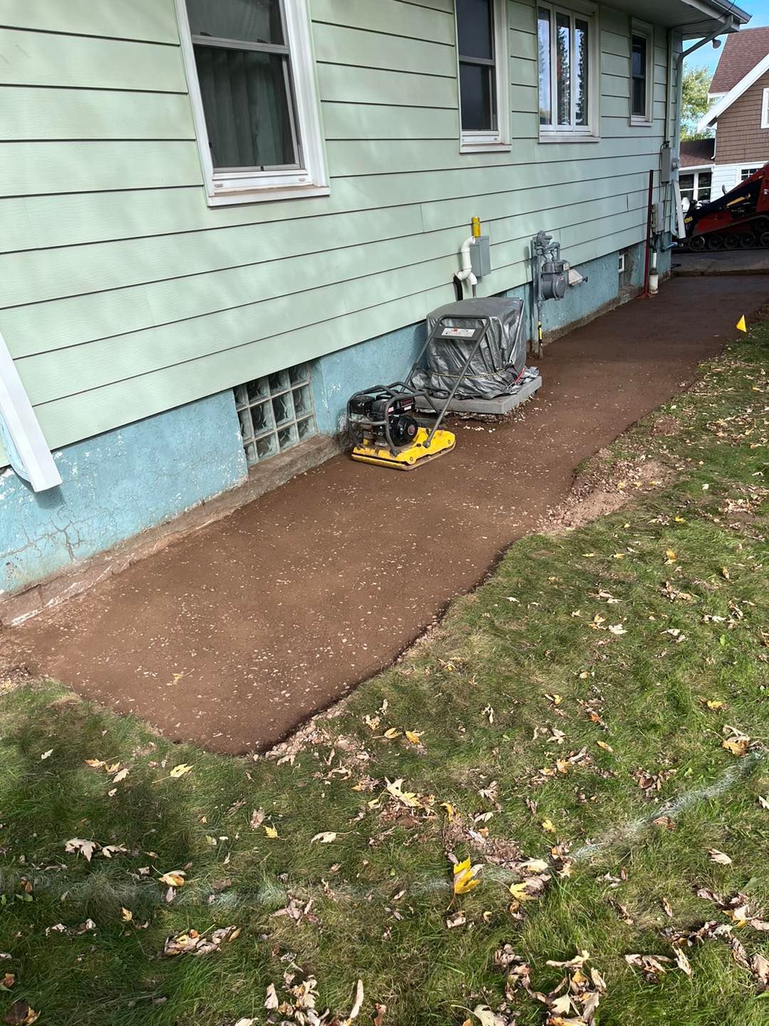 A sidewalk is being built in front of a house.
