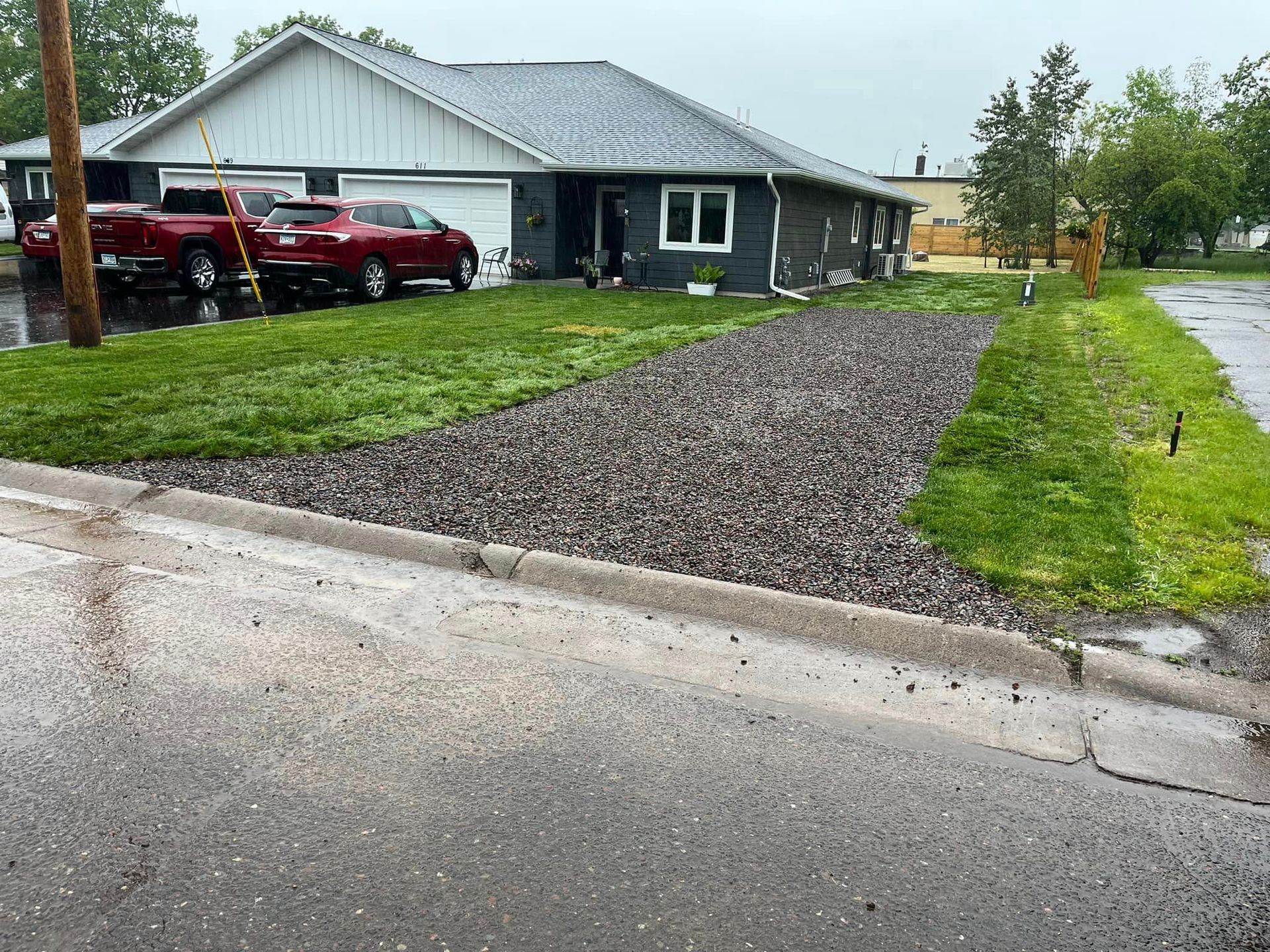 Two red trucks are parked in front of a house.