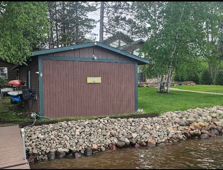 A shed is sitting next to a body of water.