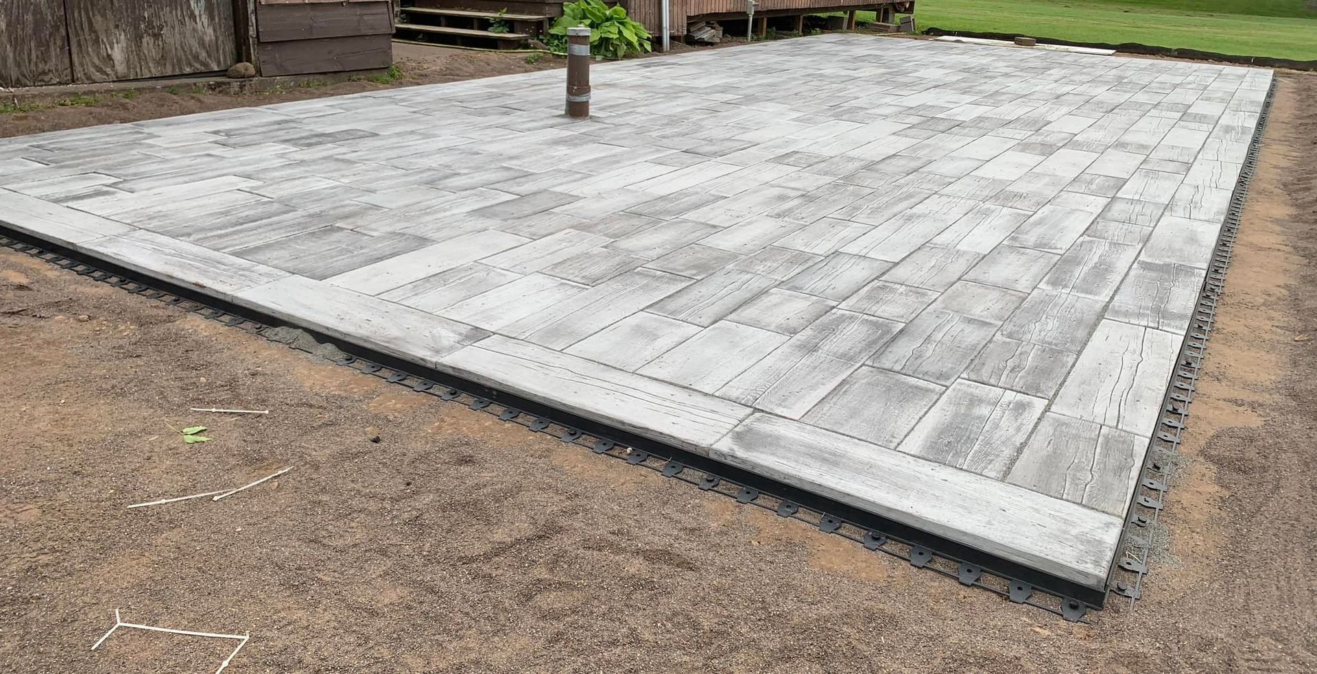 A large concrete patio with a plant in the middle of it.