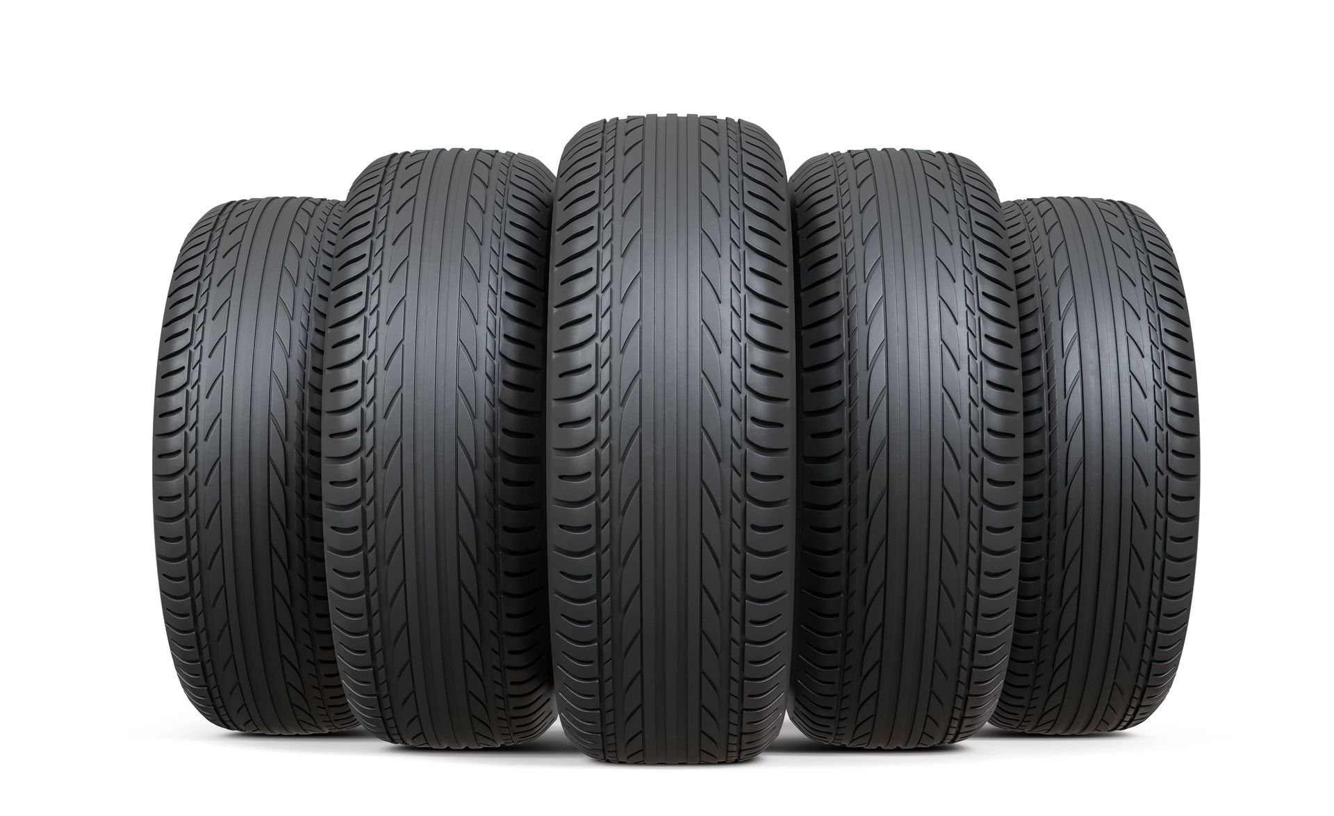 Un grupo de neumáticos están alineados en fila sobre un fondo blanco.