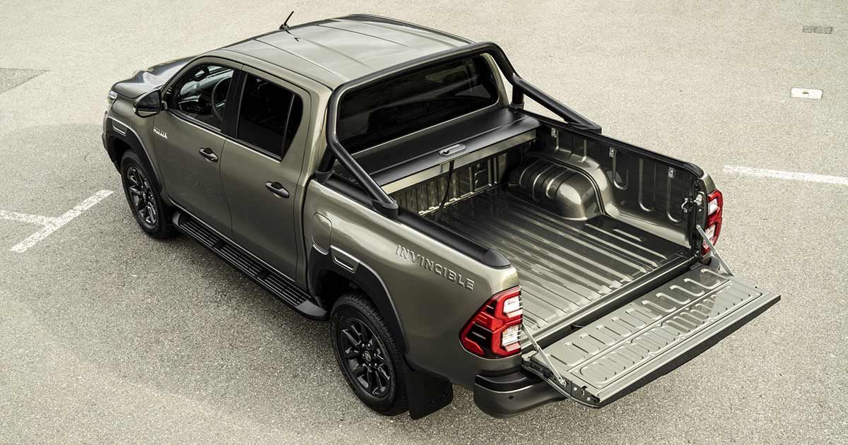Una camioneta Toyota Hilux está estacionada en un estacionamiento con la caja abierta.